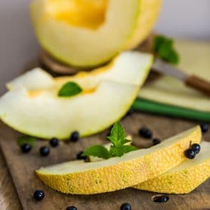 fresh melon and blueberries on a wooden cutting board. selective focus